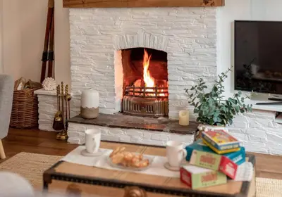 a living room with a white brick fireplace at Charming Fishing Cottage in Polruan