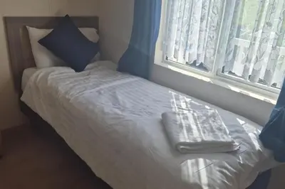 a small bed in a room with a window at Sea Breeze Villa near to Newquay sleeping 6 guests in Newquay