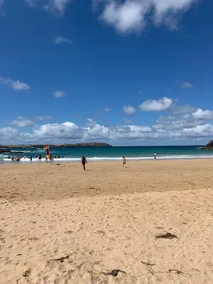 a group of people walking on a beach at Family-Friendly 3-Bed Caravan Recently Renovated on Seven Bays Holiday Park, Padstow in St Merryn