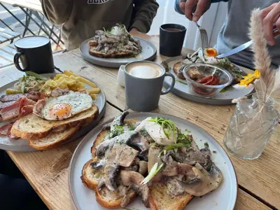 a wooden table with plates of breakfast food on it at Sunset family lodge private garden private parking in Saint Columb Minor
