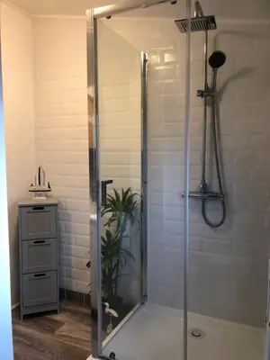 a shower with a glass door in a bathroom at Sunset family lodge private garden private parking in Saint Columb Minor