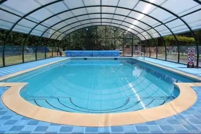 a large swimming pool with a domed roof at Sunset family lodge private garden private parking in Saint Columb Minor
