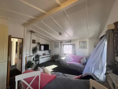 a living room with a couch and a tv at Sunset family lodge private garden private parking in Saint Columb Minor