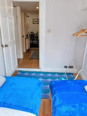 a room with a blue carpeted floor and a bed at Chapel Street Retreat in St Ives