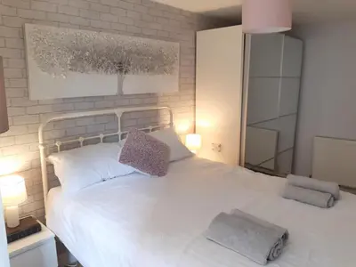 a bedroom with a white bed with two pillows on it at Chapel Street Retreat in St Ives