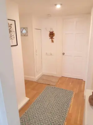 a hallway with a white door and a rug at Chapel Street Retreat in St Ives