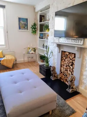 a living room with a fireplace and a couch at Chapel Street Retreat in St Ives