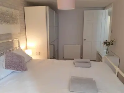 a bedroom with a large white bed with two pillows at Chapel Street Retreat in St Ives