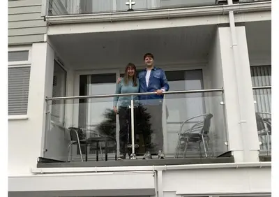 a man and a woman standing on a balcony at Foxwood in Kenwyn