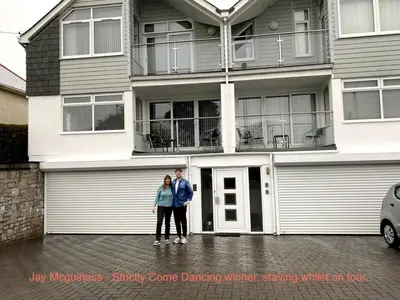 a man and woman standing in front of a house at Pencarrick in Kenwyn