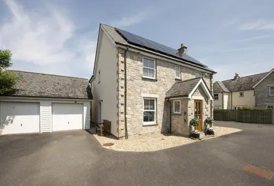 a brick house with a garage and a driveway at Puffin Way in Hayle