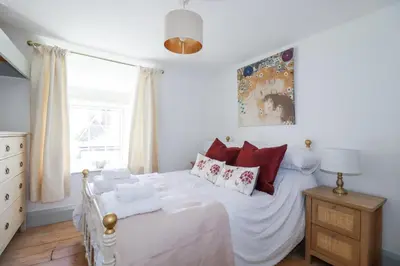 a bedroom with a white bed with red pillows at Hilldene in Tintagel
