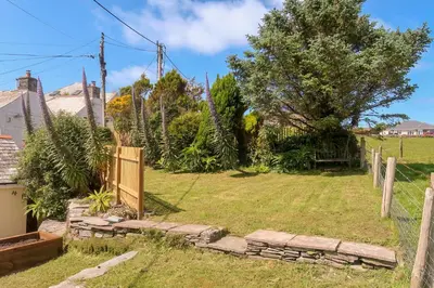 a garden with a fence and a gate at Hilldene in Tintagel