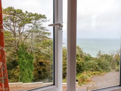 an open window with a view of the ocean at Godrevy View in St Ives