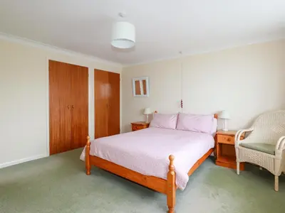 a bedroom with a bed and a chair at Godrevy View in St Ives