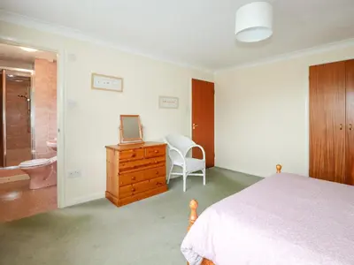 a bedroom with a bed and a bathroom with a toilet at Godrevy View in St Ives