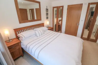 a bedroom with a white bed and a mirror at Azur in St Ives
