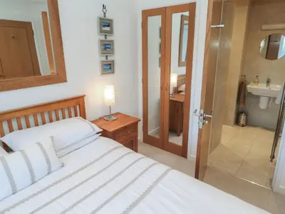 a bedroom with a bed and a bathroom with a sink at Azur in St Ives