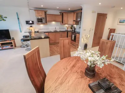 a kitchen with a wooden table with chairs and a table at Azur in St Ives