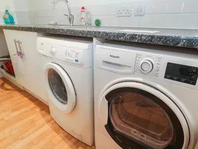 a kitchen with a washing machine and a sink at Azur in St Ives
