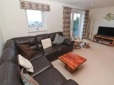 a living room with a leather couch and a coffee table at Azur in St Ives