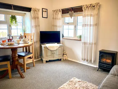 a living room with a television and a table with a tableablish at Hawthorn in Bude
