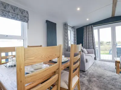 a kitchen and living room with a table and chairs at The Maples, No 48 in St Austell