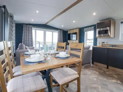 a dining room and kitchen with a table and chairs at The Maples, No 48 in St Austell