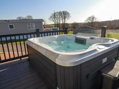 a hot tub on top of a deck at The Maples, No 48 in St Austell