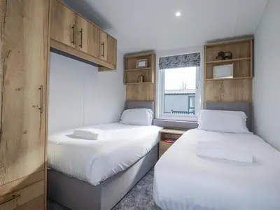 two beds in a small room with a window at The Maples, No 48 in St Austell