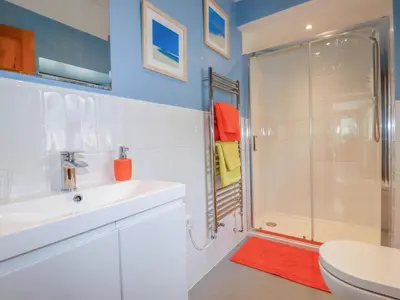 a bathroom with a shower and a sink and a toilet at The Old Piggery in Truro