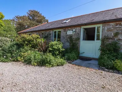 a stone house with a door and a gravel driveway at The Old Piggery in Truro