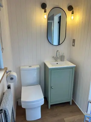 a bathroom with a toilet and a sink and a mirror at Kilden Hut - Perranwell Station in Perranwell