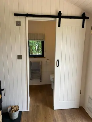 a bathroom with a toilet and a door at Kilden Hut - Perranwell Station in Perranwell