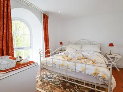 a white bed in a room with a window at Trelowth Chapel in St Austell