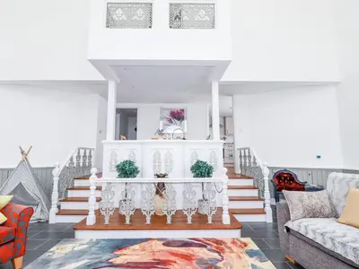 a living room with stairs and a table at Trelowth Chapel in St Austell