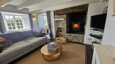 a living room with a couch and a fireplace at Sophie's Cottage in Philleigh