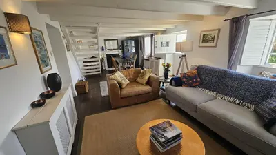 a living room with a couch and a table at Sophie's Cottage in Philleigh
