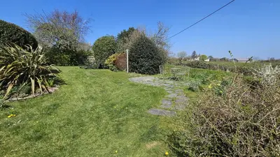 a garden with a stone path in the grass at Sophie's Cottage in Philleigh