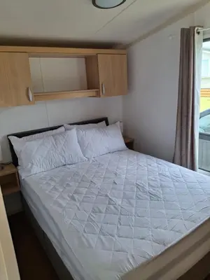 a large bed in a small room with a window at Kernow 237 in Newquay