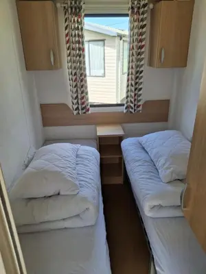two beds in a small room with a window at Kernow 237 in Newquay