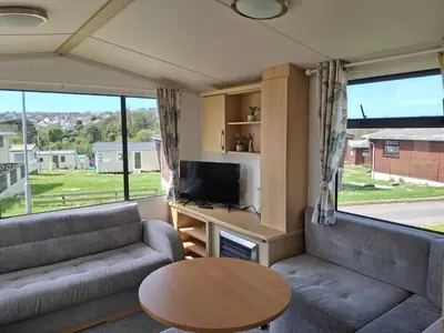 a living room with a couch and a tv and a table at Kernow 237 in Newquay
