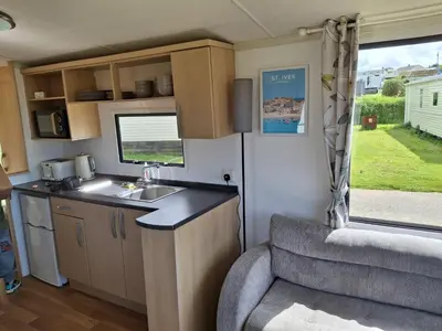 a kitchen in a caravan with a sink and a window at Kernow 237 in Newquay