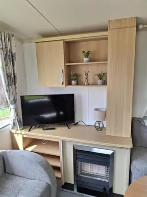 a living room with a desk with a tv and a fireplace at Kernow 237 in Newquay