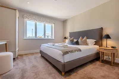 a bedroom with a large bed and a window at 4 Bed in St. Merryn oc-f31095 in St Merryn