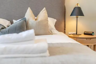 a bed with white pillows and a lamp on a table at 4 Bed in St. Merryn oc-f31095 in St Merryn