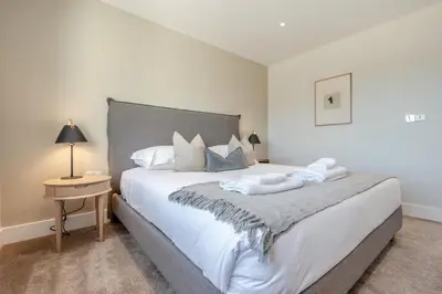 a bedroom with a large white bed and a table at 4 Bed in St. Merryn oc-f31095 in St Merryn