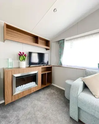 a living room with a tv and a couch at Ocean Breeze-Haven Perran Sands Holiday Park in Perranporth
