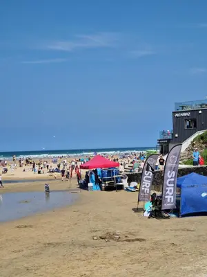 a beach with a lot of people on it at Ocean Breeze-Haven Perran Sands Holiday Park in Perranporth
