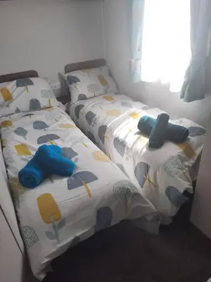 two twin beds sitting next to each other in a room at Ocean Breeze-Haven Perran Sands Holiday Park in Perranporth